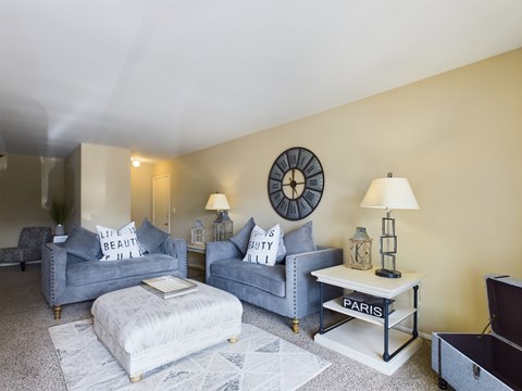 A living room with grey couches and a white coffee table.
