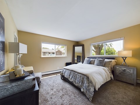 A bedroom with a large bed and a window.