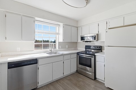 A kitchen with white cabinets and stainless steel appliances.