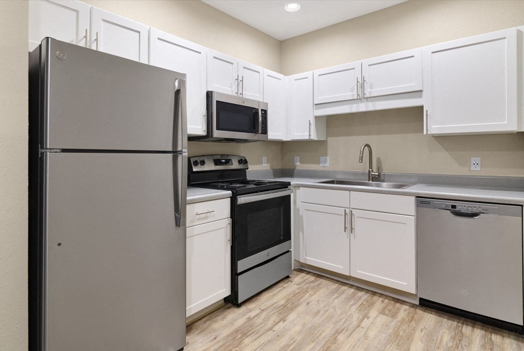 a kitchen with stainless steel appliances and white cabinets