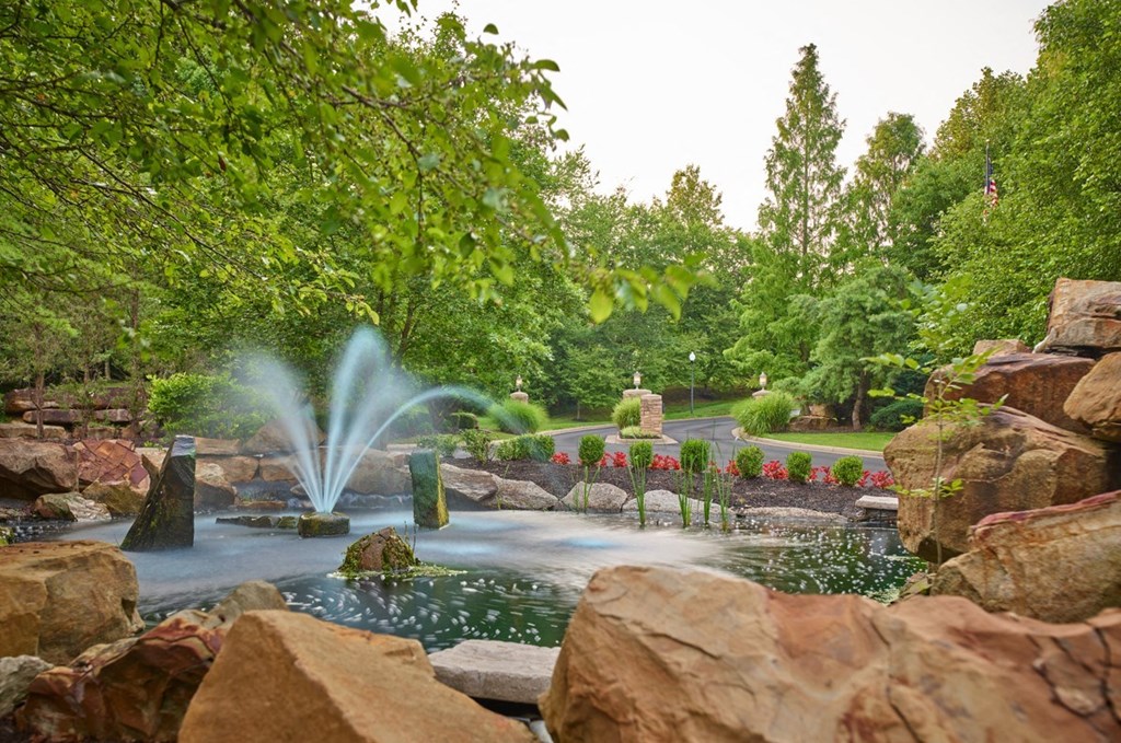 a water fountain in the middle of a pond