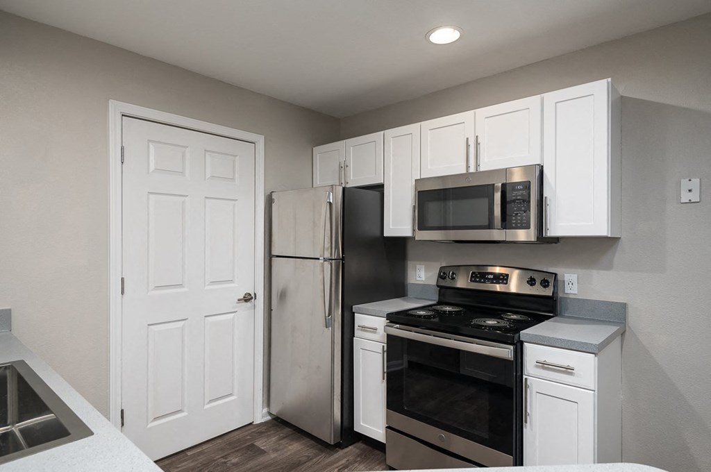 a kitchen with stainless steel appliances and white cabinets