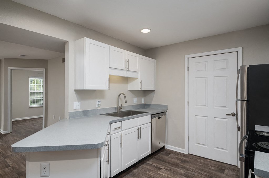 a kitchen with white cabinets and a sink and a refrigerator