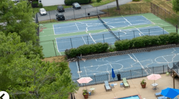 an aerial view of a house with a pool and tennis court