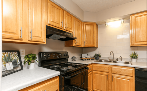 A kitchen with wooden cabinets and black appliances.