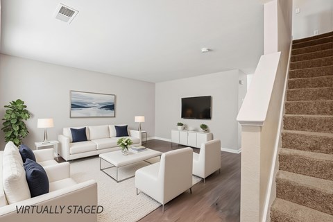 A living room with a staircase on the right side.