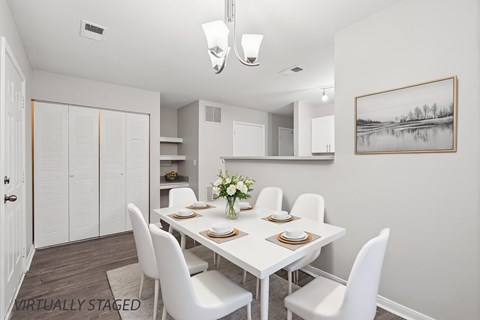 A dining room with a white table and chairs.