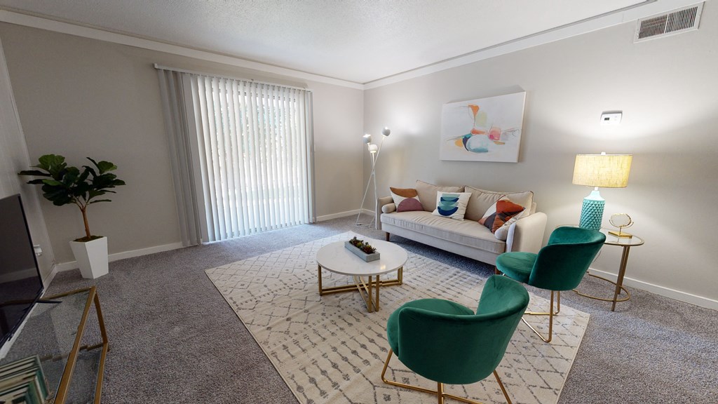 a living room with a white couch and green chairs