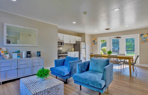 A living room with blue chairs and a wooden table.