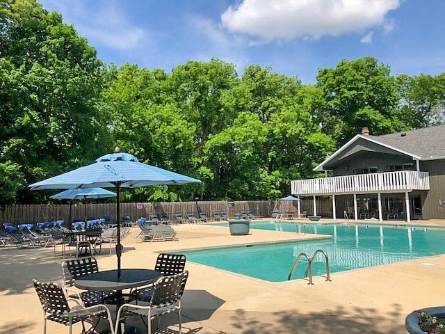 a swimming pool with tables and chairs and an umbrella