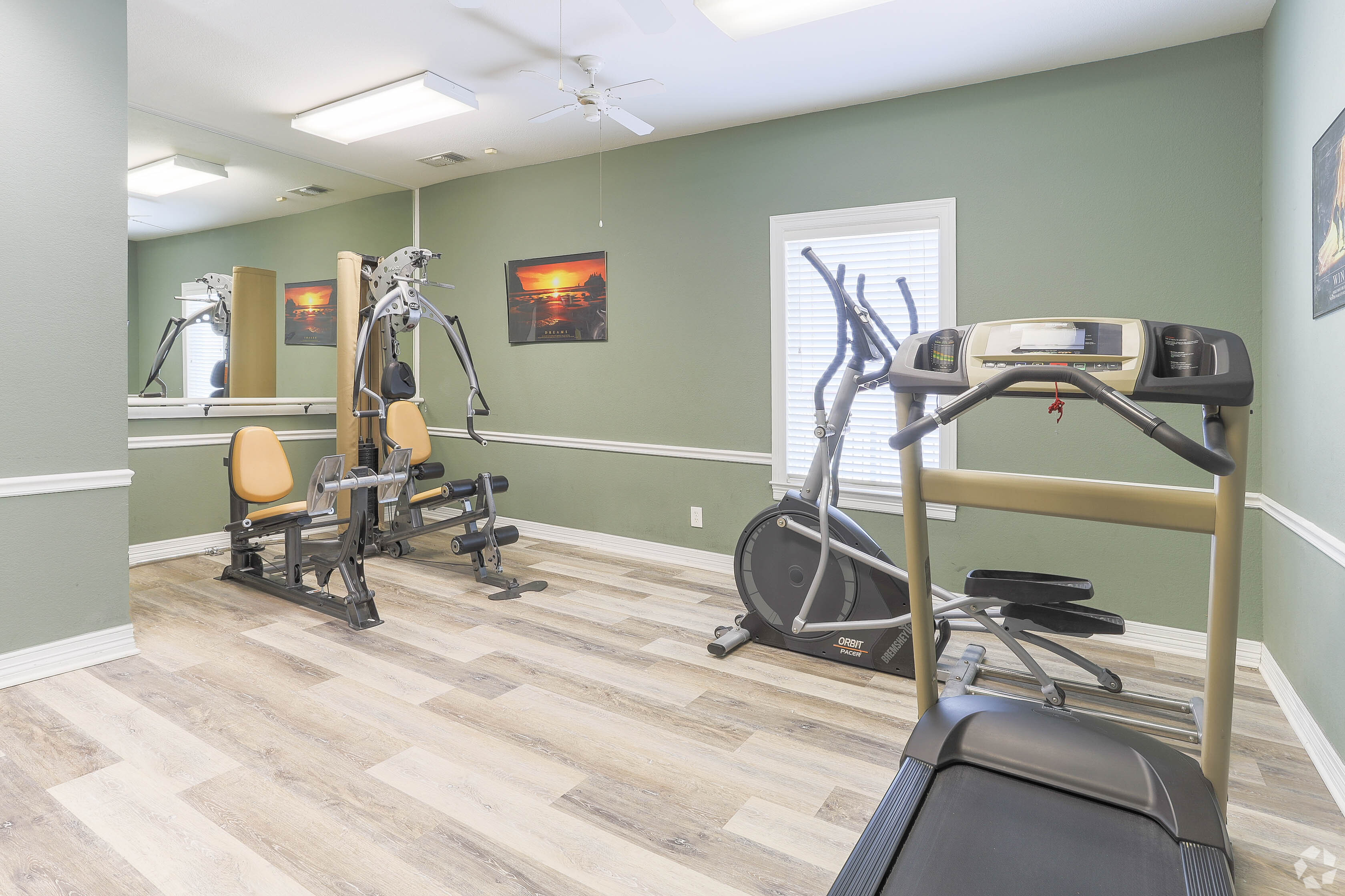 Well-equipped on-site fitness center with treadmill, exercise bike, and free weights at Waterbrook Apartments in Lincoln, Nebraska, professionally operated by Highlands Vista Group.