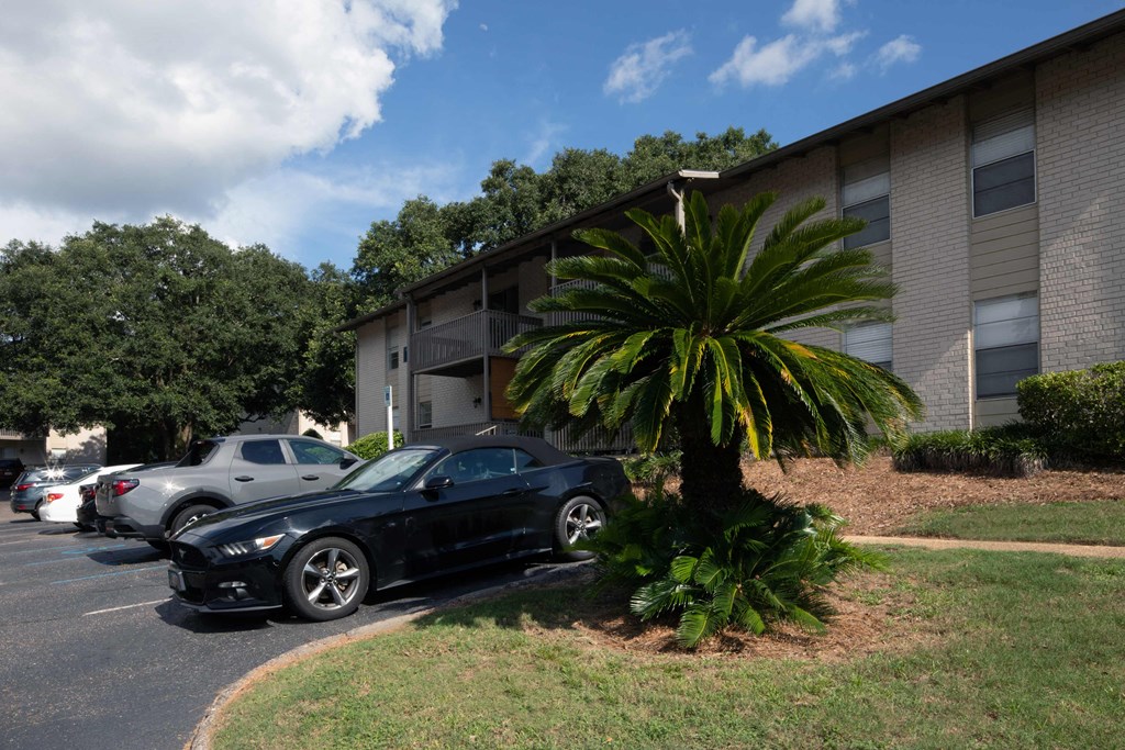 an apartment complex with cars parked in front of the leasing office