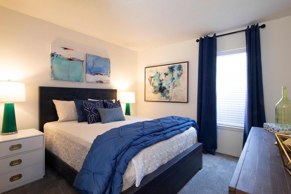 a bedroom with a large bed and a desk with a chair