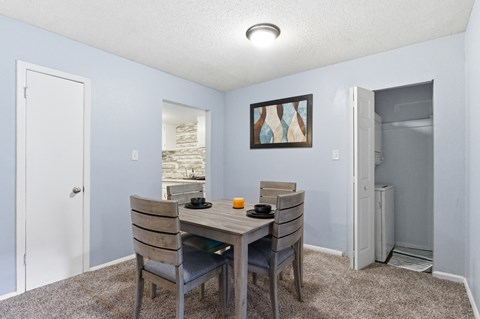 A dining room with a table and chairs.