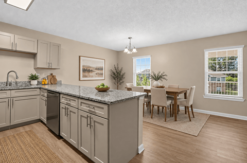 A kitchen with a dining table and chairs.