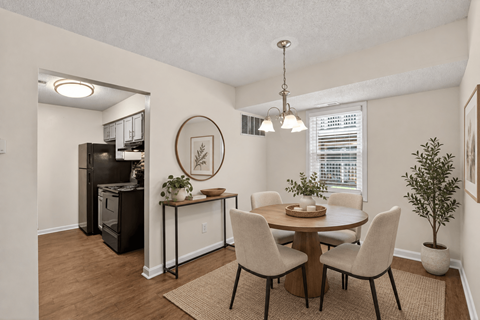 A dining room with a table set for four.
