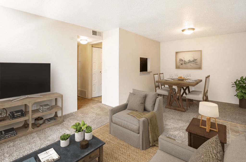 A living room with a grey couch, a wooden coffee table, and a television.