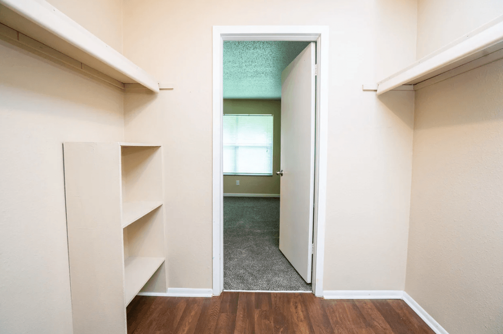 A white doorway leads to a room with a green wall.