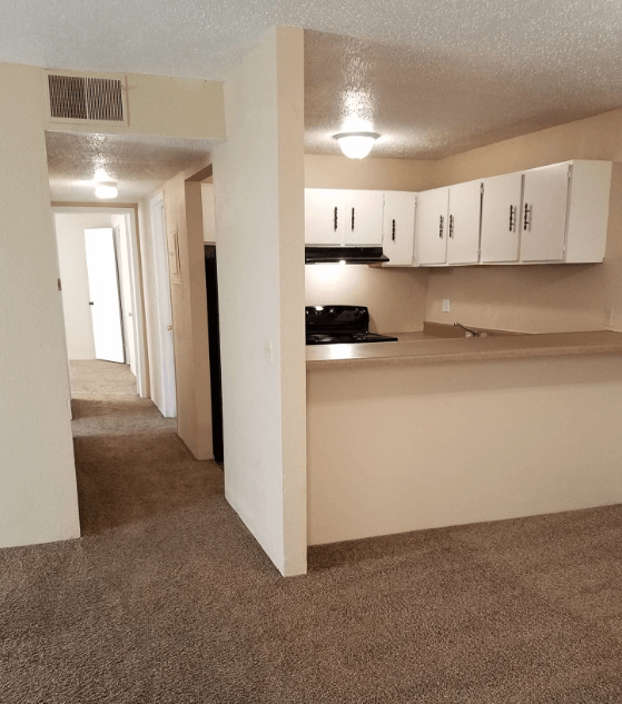 A kitchen area with white cabinets and a black stove top oven.