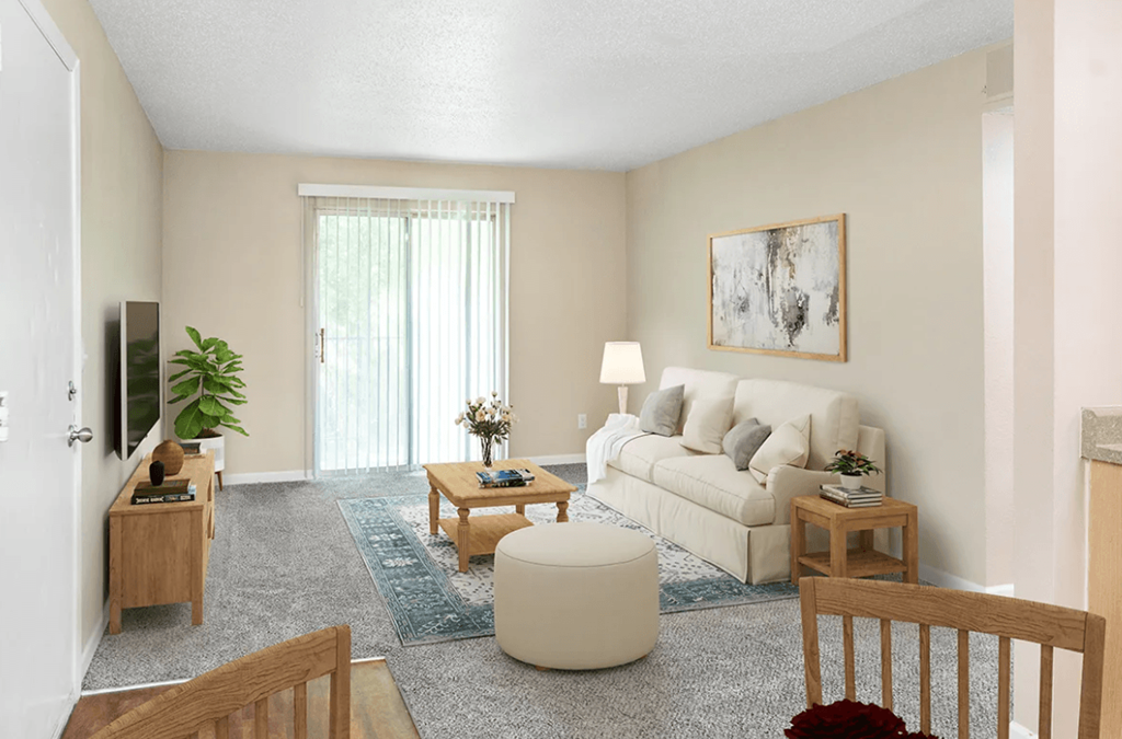 A living room with a white couch, a coffee table, and a television.
