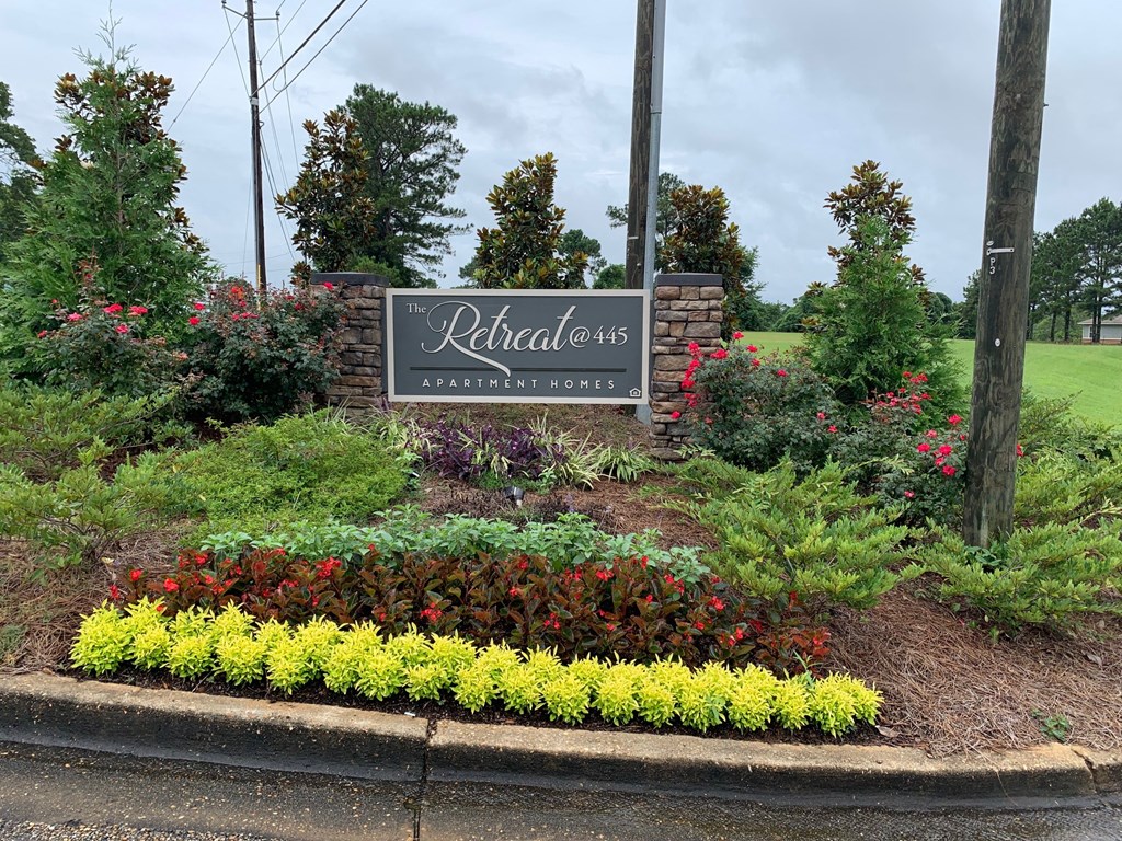 a sign for the relentless landscaping company in front of a garden