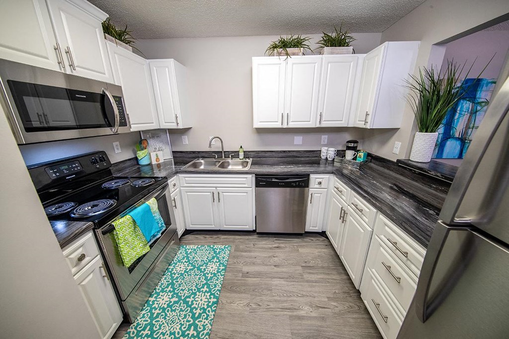 a kitchen with stainless steel appliances and white cabinets