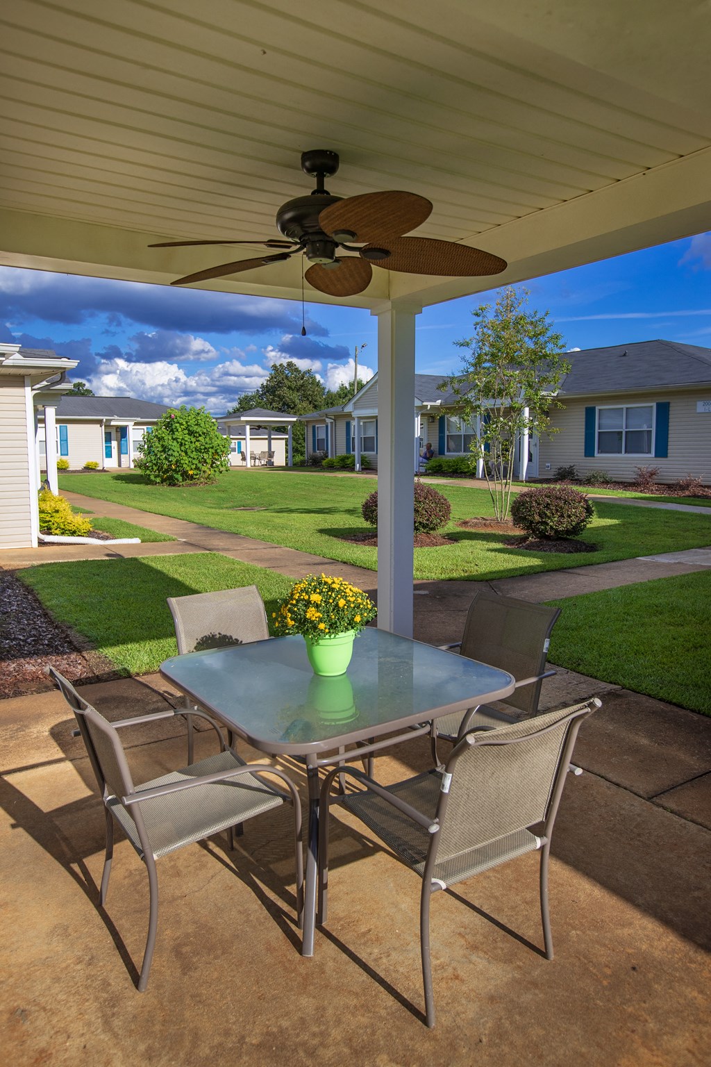 a patio with a table and chairs and a ceiling fan