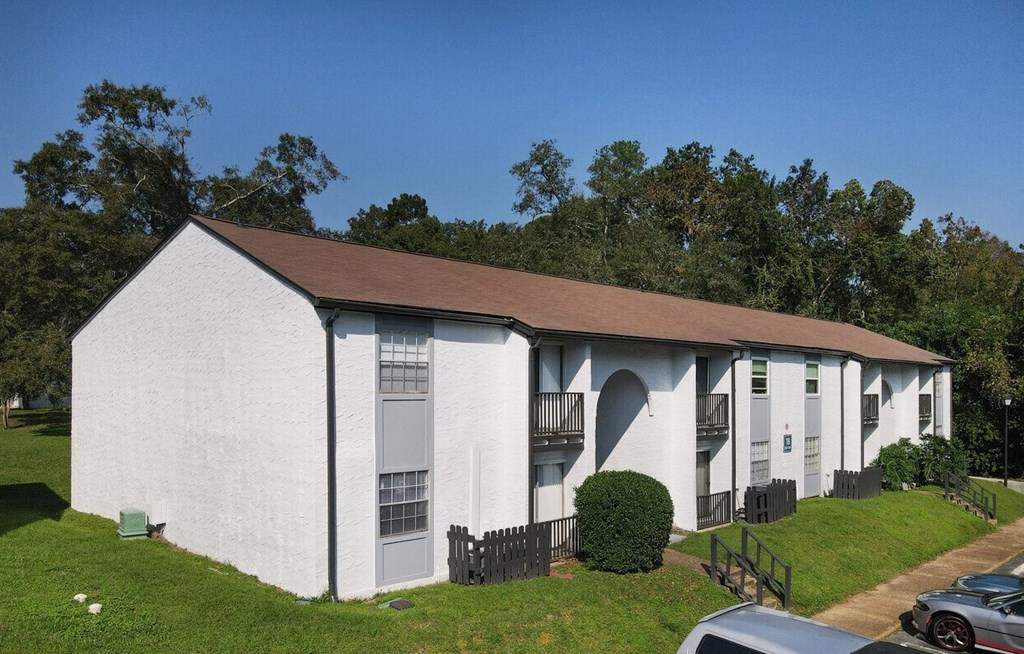 an old white building with cars parked in front of it