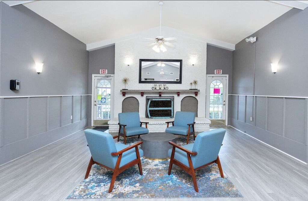 a living room with a table and chairs in front of a fireplace