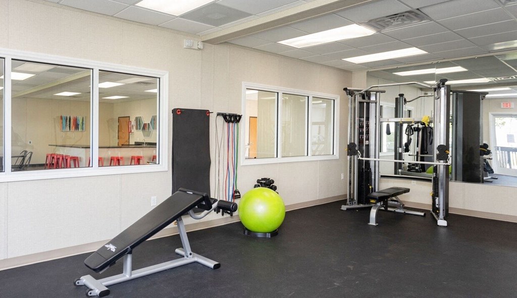 a gym with weights and a ball on the floor