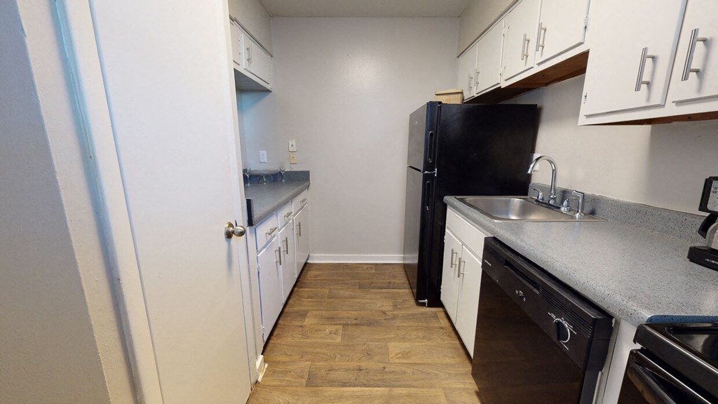 a kitchen with white cabinets and a black refrigerator