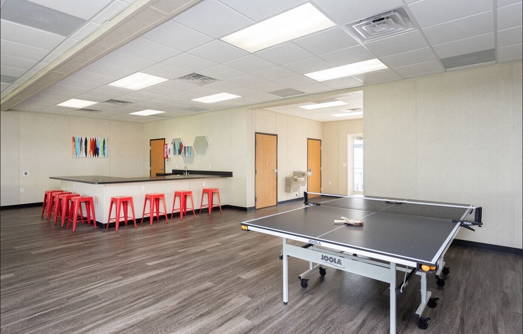 a game room with a ping pong table and a bar