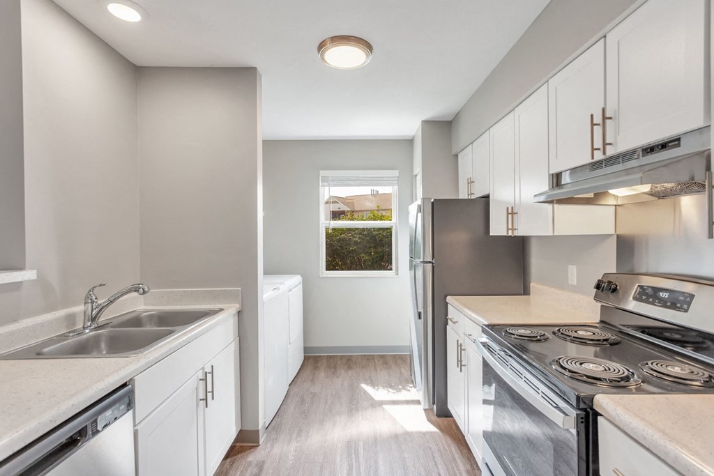 a kitchen with white cabinets and stainless steel appliances