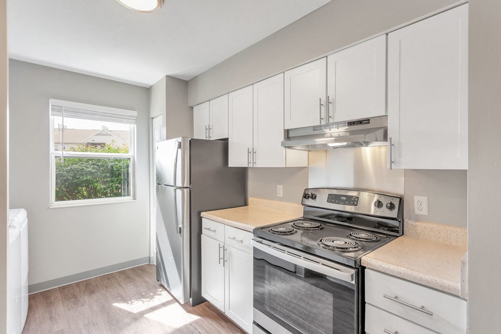 a kitchen with white cabinets and stainless steel appliances