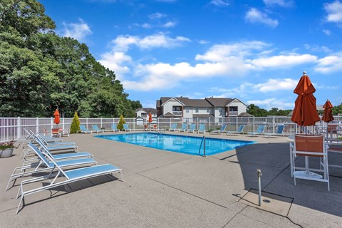 Resort-style pool with lounge chairs at Arbor Crossings Muskegon MI