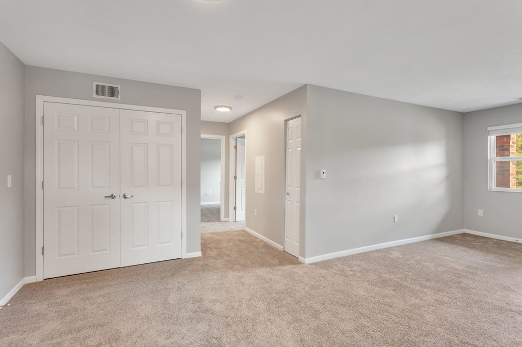 the living room and bedroom of an empty home with white doors