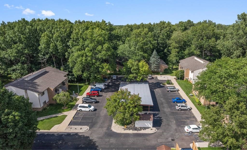 an aerial view of a neighborhood with cars parked in a parking lot