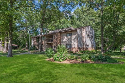 a house in the middle of a yard with trees