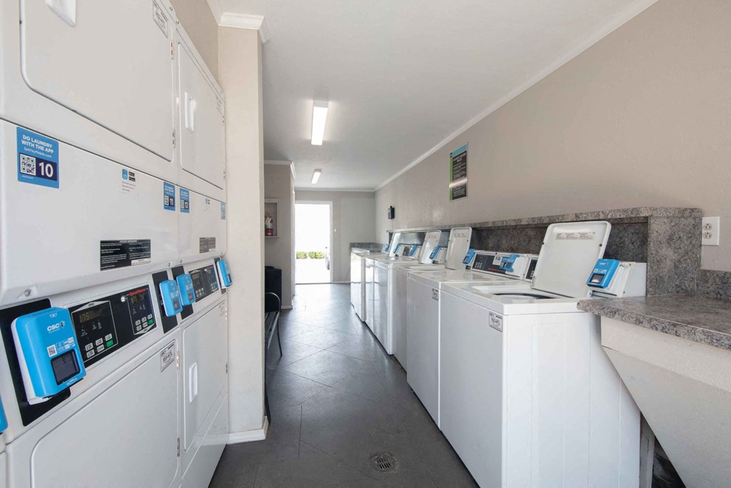 a row of washers and dryers in a laundromat