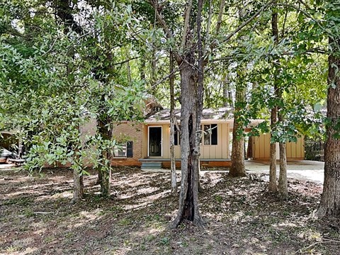 A house is surrounded by trees in a wooded area.