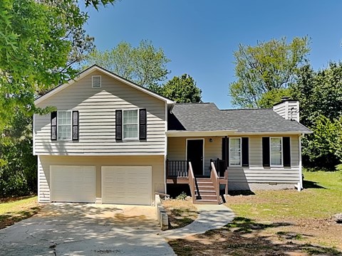 A house with a grey siding and a white garage door.