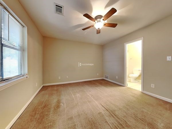 an empty living room with a ceiling fan and a window
