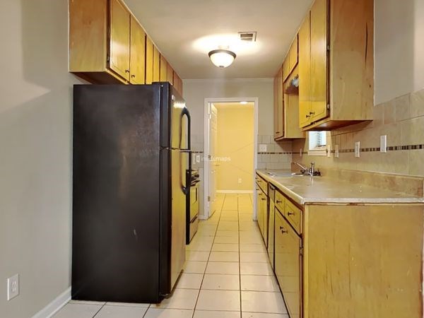 a kitchen with a black refrigerator and a sink