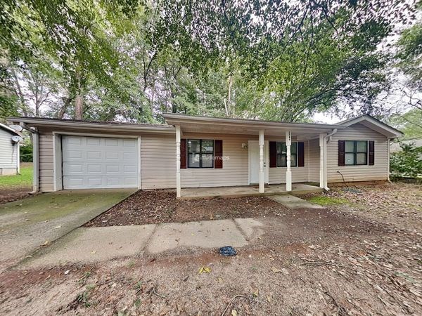a small white house with a yard and trees