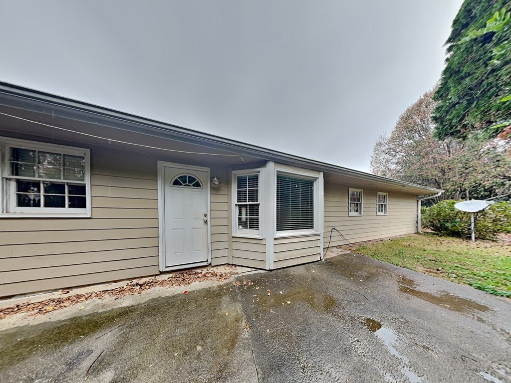 the front of a house with a white door and a driveway