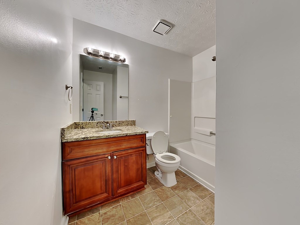 a bathroom with a toilet and a sink and a mirror