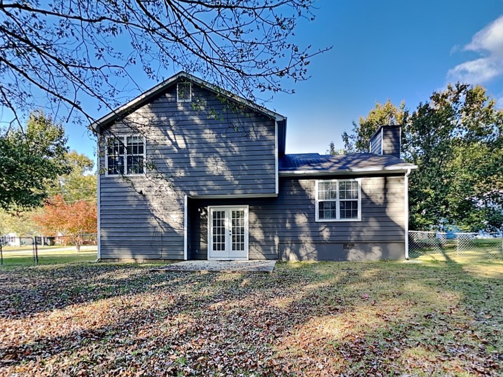 a blue house with a yard and a fence