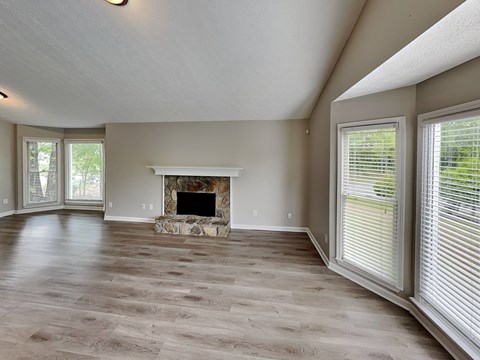 A living room with a fireplace and wood flooring.