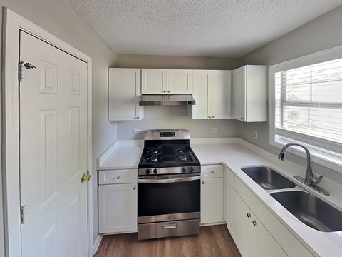 A kitchen with a stove top oven and a sink.