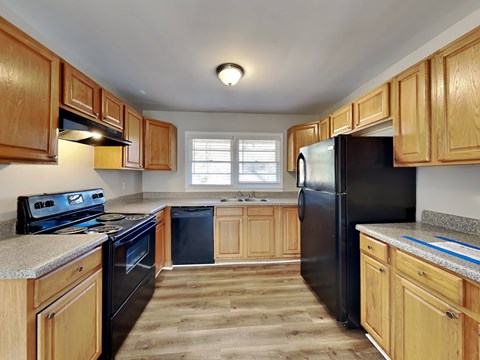A kitchen with wooden cabinets and black appliances.